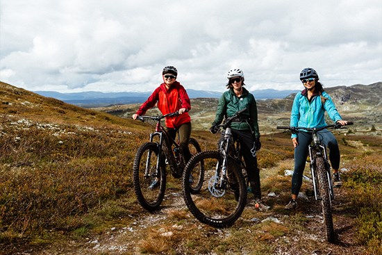 tre damer som er på hver sin sykkel og smiler
