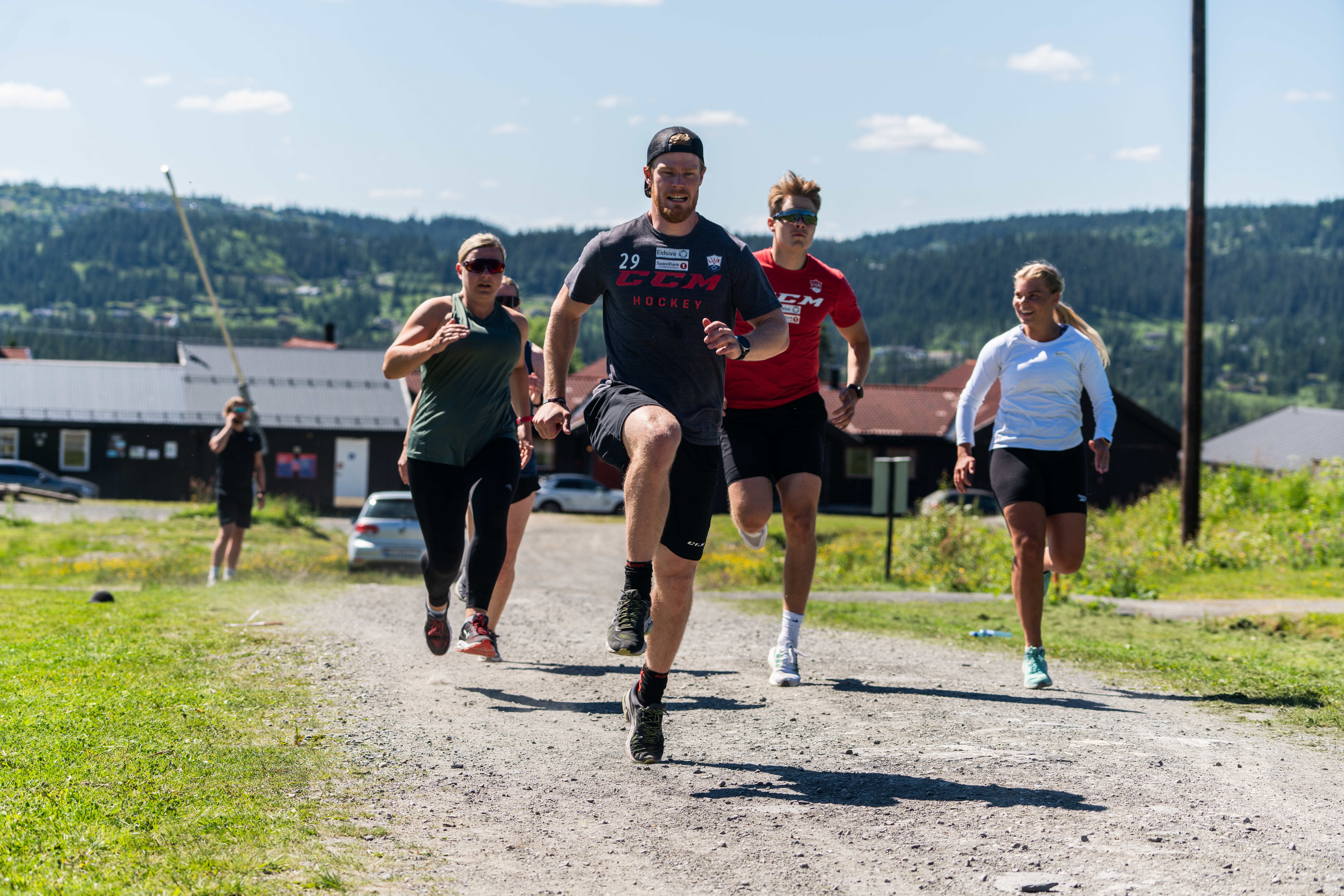 Fire personer som løper langs en sti