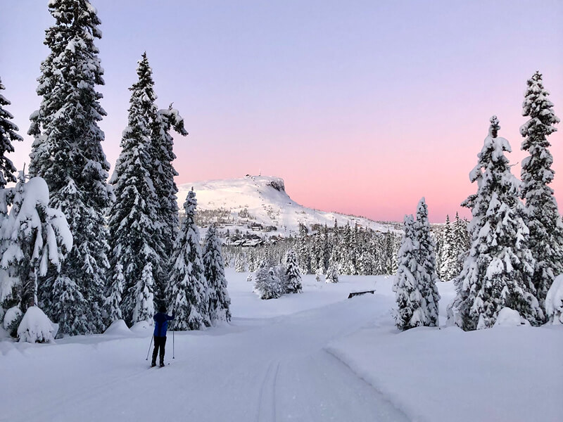 Vinterbilde med skiløyper og skeikampen i bakgrunnen