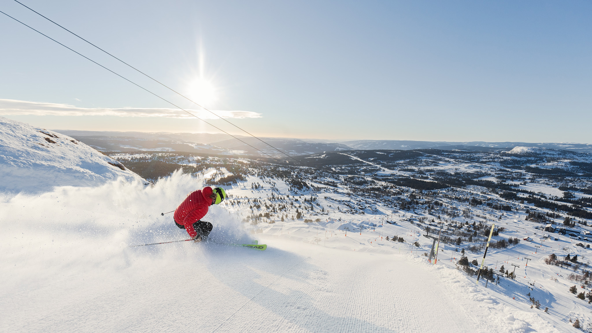 Familie på ski i alpinanlegget på Skeikampen i herlig sol.